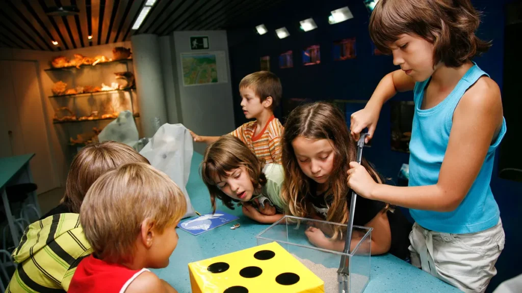 Niños participan en una práctica, observando con atención un experimento guiado sobre las estrategias de supervivencia.